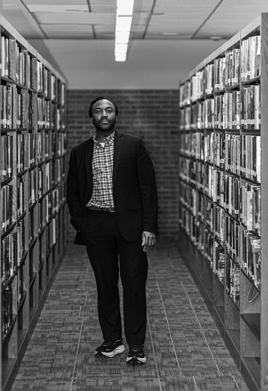 Dr. Adam Stevens standing in a library