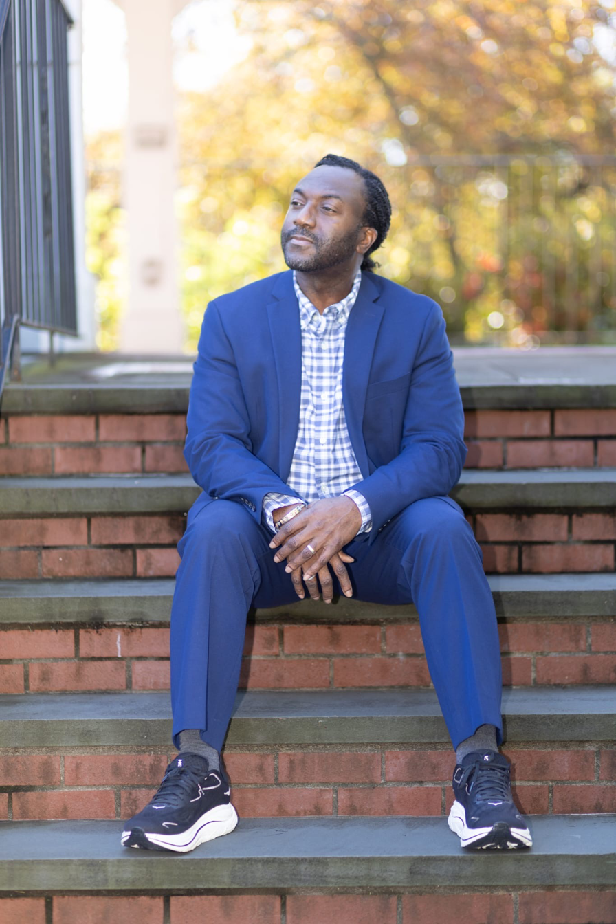 Dr. Adam Stevens seated on brick steps